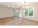 Bright living room with hardwood floors, large windows, a ceiling fan, and a glass door to the backyard at 213 Clement Ave, Oxford, NC 27565