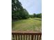 Expansive backyard featuring mature trees, a wooden fence, and a charming play area at 216 Edgecombe Dr, Spring Lake, NC 28390