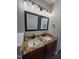 Bathroom vanity featuring dual sinks, granite countertop, modern faucets, and framed mirrors at 216 Edgecombe Dr, Spring Lake, NC 28390