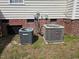 Two HVAC units positioned outside the house with brick foundation and beige siding at 216 Edgecombe Dr, Spring Lake, NC 28390