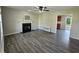 Bright living room featuring a fireplace, ceiling fan, and gray-toned wood floors at 216 Edgecombe Dr, Spring Lake, NC 28390