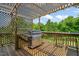 Outdoor kitchen with grill on a wooden deck and partially screened-in patio perfect for summer barbecues at 216 Tarkenton Ct, Clayton, NC 27527