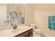 Bright bathroom featuring a single sink vanity, toilet and shower with blue and green floral curtain at 216 Tarkenton Ct, Clayton, NC 27527