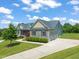 Charming exterior elevation with stone accents, landscaping and a three-car garage at 216 Tarkenton Ct, Clayton, NC 27527