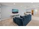 Bright living room with blue walls featuring a sofa, TV, wooden cabinet and rocking chair at 216 Tarkenton Ct, Clayton, NC 27527