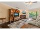 Comfortable living room with hardwood floors, a fireplace, a large window, and a sliding door to a deck at 216 Tarkenton Ct, Clayton, NC 27527