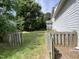 Large backyard with a wooden fence, grassy area, and mature trees providing shade and privacy at 2208 Fieldmont Ct, Raleigh, NC 27614