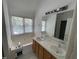 Bright bathroom with soaking tub, double sinks, and large mirror at 2208 Fieldmont Ct, Raleigh, NC 27614