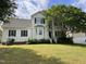Charming white two-story home with green shutters and a well-manicured lawn on a sunny day at 2208 Fieldmont Ct, Raleigh, NC 27614