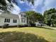 White two-story home with manicured lawn, mature trees, and a driveway, creating an inviting curb appeal at 2208 Fieldmont Ct, Raleigh, NC 27614