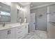 Elegant bathroom with double vanity, framed mirrors, and walk-in shower with beautiful tile work at 224 Midden Way, Holly Springs, NC 27540