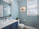 Charming powder room with modern vanity, paint, and stylish seashell art at 224 Midden Way, Holly Springs, NC 27540