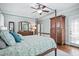Cozy bedroom featuring a four-poster bed with blue accents, hardwood floors, and plenty of natural light at 224 Midden Way, Holly Springs, NC 27540