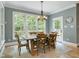 Inviting dining area with a wooden table, chairs, chandelier, large windows and tile floor at 224 Midden Way, Holly Springs, NC 27540