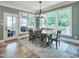 Inviting dining area featuring a wooden table, chairs, a stylish chandelier, and large windows with views at 224 Midden Way, Holly Springs, NC 27540