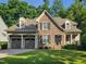 Charming stone and siding home featuring a two-car garage and a well-manicured lawn at 224 Midden Way, Holly Springs, NC 27540