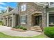 Close-up of a home's stone entrance, complemented by lush landscaping and a two-car garage at 224 Midden Way, Holly Springs, NC 27540