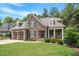 Beautiful two-story home with a stone facade, dormer windows, and manicured landscaping at 224 Midden Way, Holly Springs, NC 27540