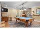 Spacious game room with a billiard table and view of the piano area and stairs to the upper level at 224 Midden Way, Holly Springs, NC 27540