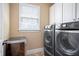 Efficient laundry room with modern washer/dryer, storage cabinets, and natural light at 224 Midden Way, Holly Springs, NC 27540