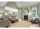 Spacious living room with a fireplace, large windows, neutral tones, and an open view to the kitchen at 224 Midden Way, Holly Springs, NC 27540