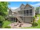 Beautiful backyard with a stone patio, wooden chairs, lush landscaping, and a view of the home's screened porch at 224 Midden Way, Holly Springs, NC 27540