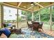 Comfortable screened-in porch with wicker furniture, an area rug and ceiling fan, perfect for relaxing and enjoying the outdoors at 224 Midden Way, Holly Springs, NC 27540