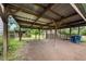 Large carport featuring a metal roof and wooden support beams in a backyard setting at 2631 Harvard Ave, Durham, NC 27703