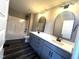 Bathroom with modern double sink vanity, arched mirrors, and a tub-shower combo at 2661 Bowden Dr, Creedmoor, NC 27522
