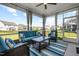Enclosed sunroom with blue patio furniture, curtains, and views of the backyard at 3333 Jones Lake Rd, Fuquay Varina, NC 27526
