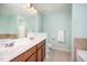 A bathroom offers a dual sink vanity with light countertop, a toilet, a shower and a tiled bathtub at 3403 Cardinal Lake Dr, Durham, NC 27704