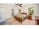 Bedroom features a ceiling fan, carpeted floors, and a connected bathroom space with plentiful sunlight from two windows at 3403 Cardinal Lake Dr, Durham, NC 27704