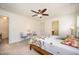 A bedroom with a ceiling fan, carpet, and a pair of blue chairs is brightened by natural light at 3403 Cardinal Lake Dr, Durham, NC 27704