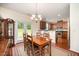 Charming dining area open to the kitchen, featuring hardwood floors and a modern chandelier at 3403 Cardinal Lake Dr, Durham, NC 27704