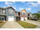 Exterior of the townhomes with private driveways, colorful siding, and well-kept landscaping at 3403 Cardinal Lake Dr, Durham, NC 27704