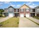 Charming townhomes featuring colorful siding, individual driveways, and attached garages at 3403 Cardinal Lake Dr, Durham, NC 27704