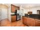 A stainless steel refrigerator, dark granite countertops, wood cabinets, and wood flooring define this home's lovely kitchen at 3403 Cardinal Lake Dr, Durham, NC 27704