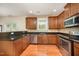 A kitchen with stainless steel appliances, wood cabinets, granite countertops, and hardwood flooring is pictured at 3403 Cardinal Lake Dr, Durham, NC 27704