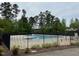 Community pool surrounded by lush trees and protected by a black metal fence at 3403 Cardinal Lake Dr, Durham, NC 27704
