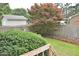Scenic backyard view from a wooden deck, showcasing mature trees, fencing, and lush greenery at 3610 Lambert Ln, Rocky Mount, NC 27804