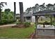 Landscaped front yard featuring mature trees, flowering plants, and a decorative well structure at 3610 Lambert Ln, Rocky Mount, NC 27804