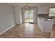 Eat-in kitchen offers wood-look floors, white cabinets and bar seating with sliding glass door access to back deck at 3610 Lambert Ln, Rocky Mount, NC 27804