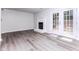 Bright living room featuring sleek floors, a cozy fireplace, and French doors to the backyard at 404 Shannonford Ct, Wake Forest, NC 27587