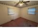 This is a bedroom featuring two windows and a ceiling fan, awaiting personalization and comfort at 603 Pineland St, Sanford, NC 27330