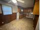 A full view of the kitchen showing an aging setup with wood paneled walls at 603 Pineland St, Sanford, NC 27330