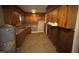 Full view of the kitchen showing stained cabinets and aging appliances at 603 Pineland St, Sanford, NC 27330