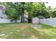 A partially fenced backyard is complete with a shed and mature trees at 604 Mills St, Raleigh, NC 27608