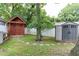 A fenced backyard includes two storage sheds and mature landscaping at 604 Mills St, Raleigh, NC 27608