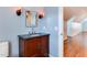 Cozy bathroom with a dark countertop vanity, sconce lighting, and hardwood floors at 604 Mills St, Raleigh, NC 27608