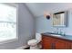 Cozy bathroom with a dark countertop vanity and sconce lighting with a neutral color scheme at 604 Mills St, Raleigh, NC 27608